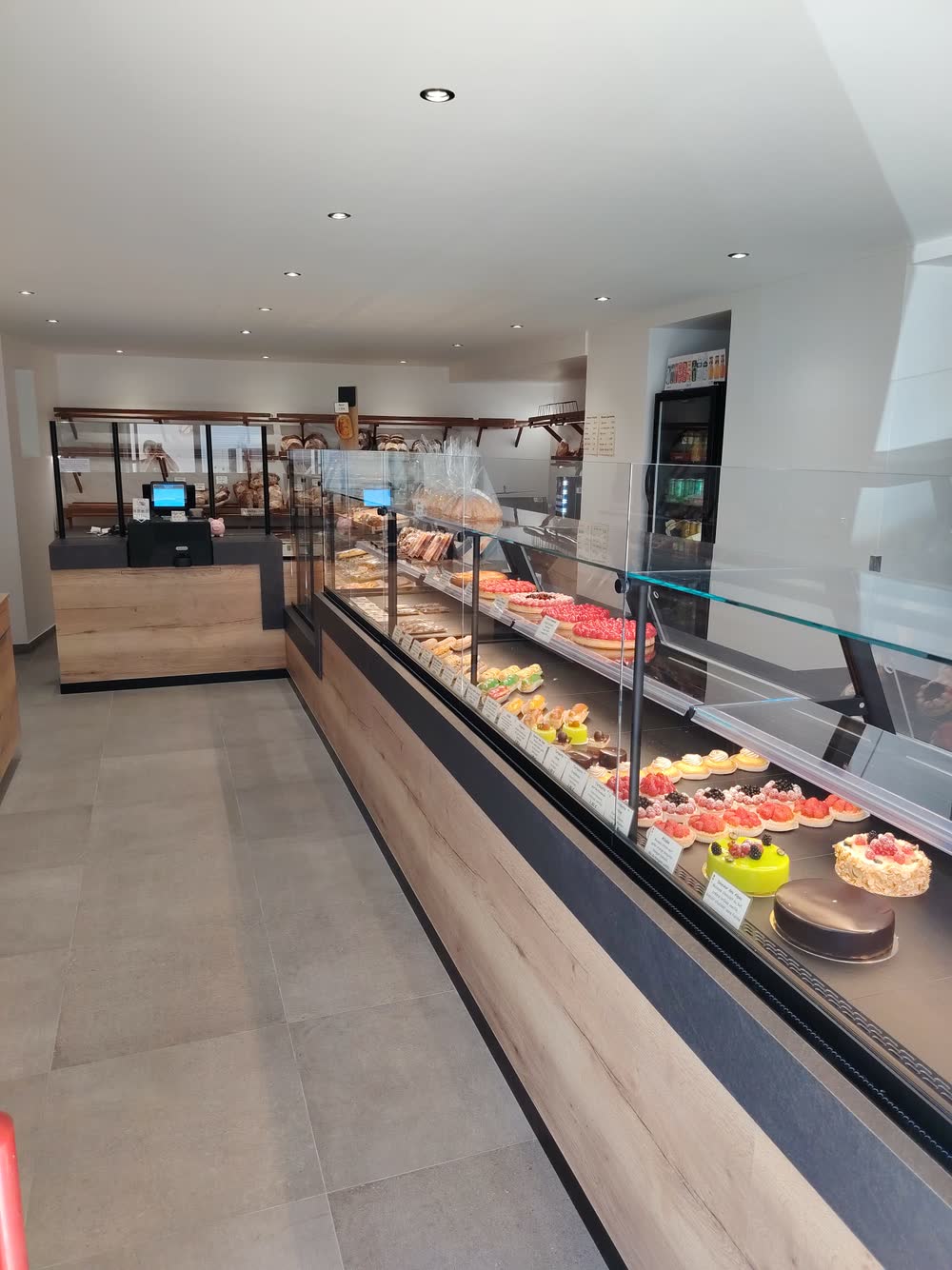 La boutique rénovée de la Boulangerie Teixeira : comptoir en bois et vitrine de pâtisseries