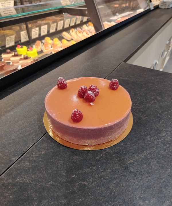 Entremets à la framboise posé devant la vitrine